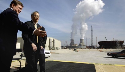 
              FILE- In this Feb. 15, 2012 file photo, U.S. Secretary of Energy Secretary Steven Chu, right, exits the stage with Southern Company President and CEO Thomas Fanning as cooling towers fo